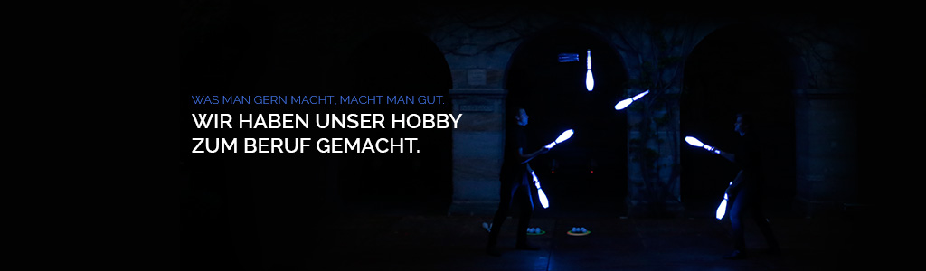 2 people Juggling 6 blue LED clubs on castle stage